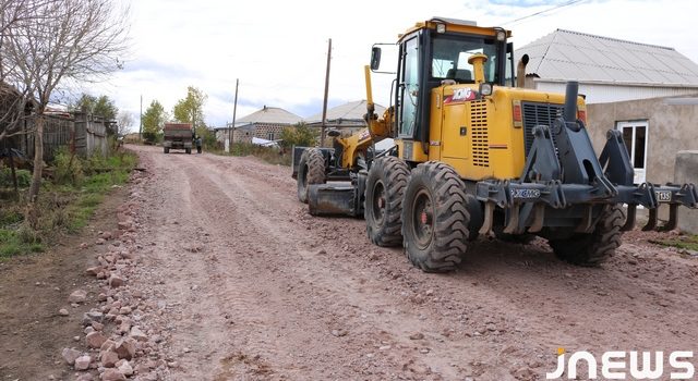 Выравнивание дороги большими и острыми камнями